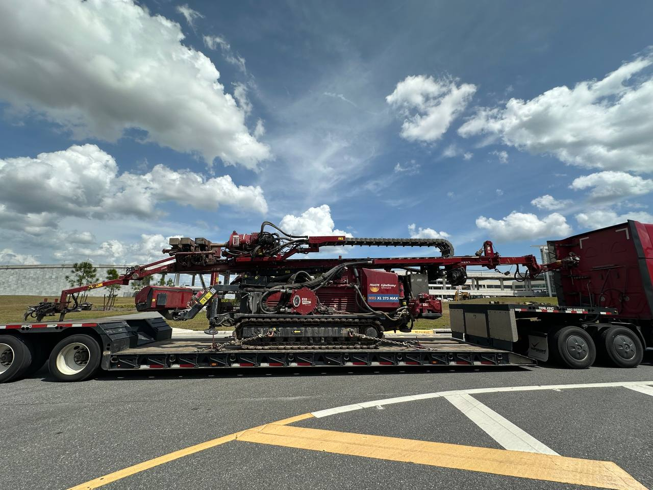 A tracked drilling rig transported on a step-deck trailer