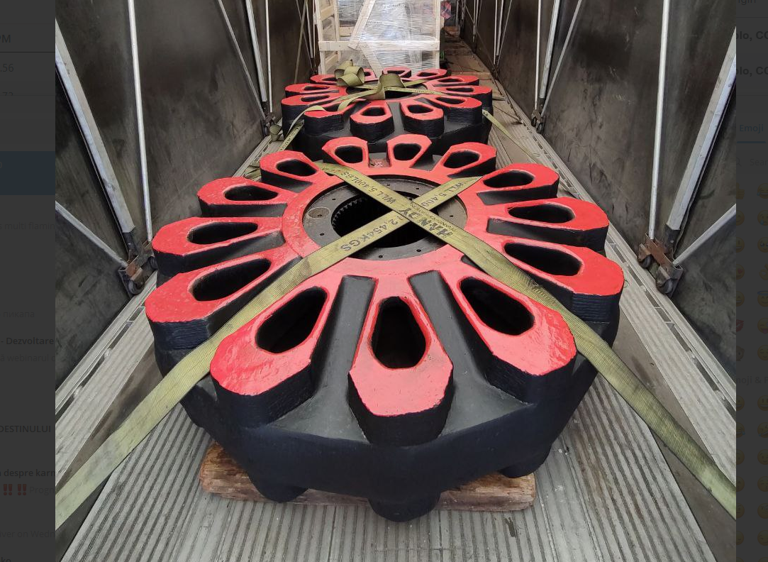 An oversized red-and-black industrial impeller secured with chains on a flatbed deck