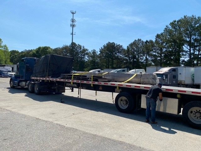 A wrapped, palletized partial load secured for cross-country flatbed transport