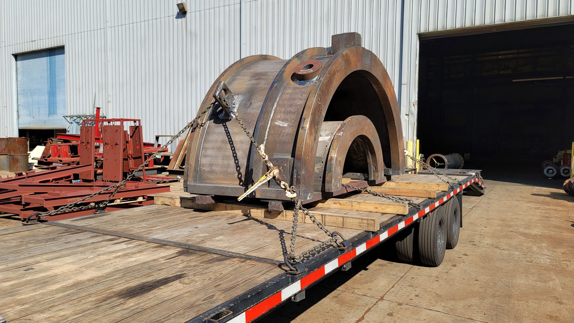 Heavy machined steel components — big iron — chained on a flatbed